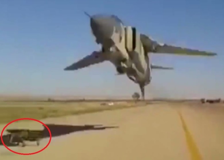 男子(红圈)吓得抱头伏在地上躲避,战机在其头顶不足2米掠过呼啸而去。