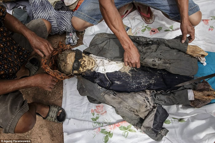 印尼小村庄“Torajan”举办鬼节:村民把过世先人从棺木内取出换上新衣服游街