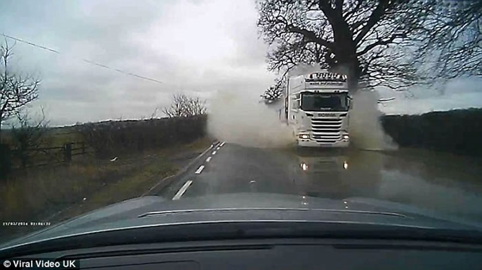 惊险一刻!英国车主驾车乡间行驶 突然被对面货车高速驶至溅起的水花瞬间“淹没”