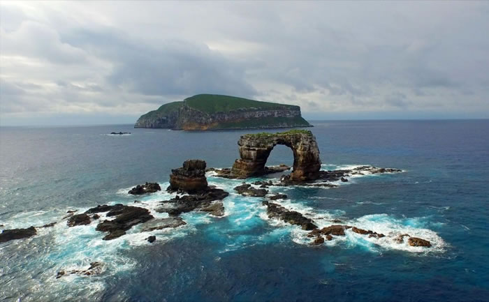 达尔文岛(远景)与达尔文拱门(近景)一带,物种丰富多元。 PHOTOGRAPH BY NEIL GELINAS, NATIONAL GEOGRAPHIC