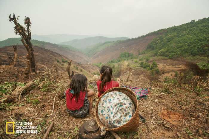 在老挝南尔国家公园西侧,当地两位小女孩坐在山头上休息。寮国境内的木材公司大多来自中国大陆,将木材输入中国制成家具,导致保护区以外的森林被砍伐殆尽。 Photog