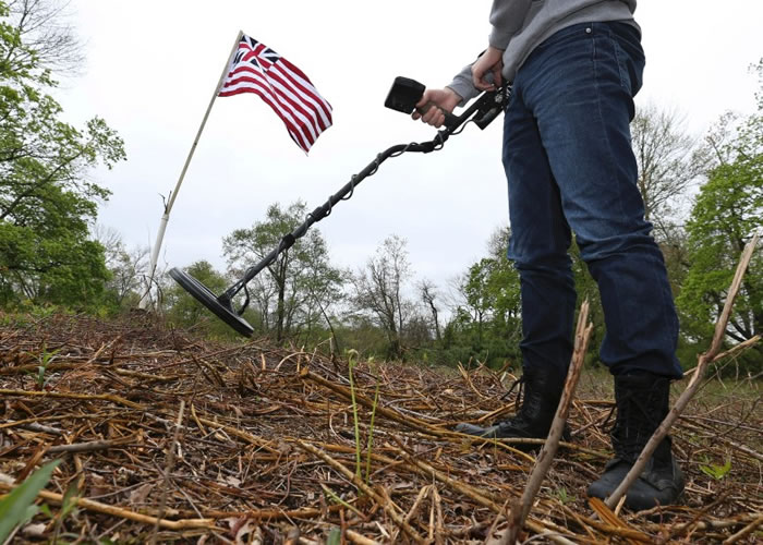专家利用金属仪器探测地面。
