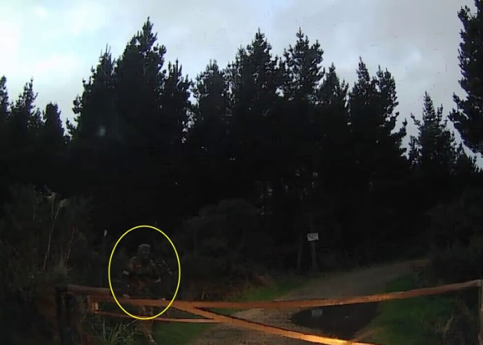 蒙头男子(黄圈)手执一支铁笔从路旁丛林走出来。