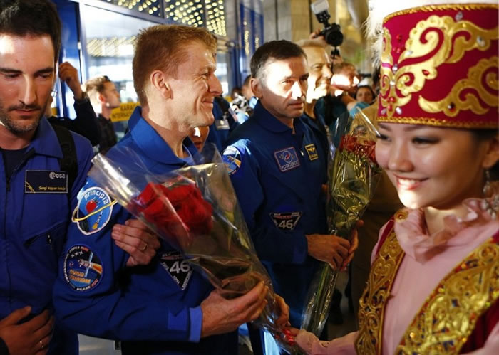 皮克(左二)早前于哈萨克降落,并接受献花。