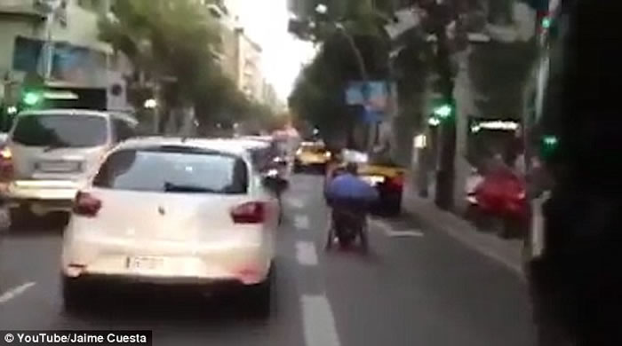 西班牙马路上演惊人一幕:坐轮椅男子在路上飞驰险象横生