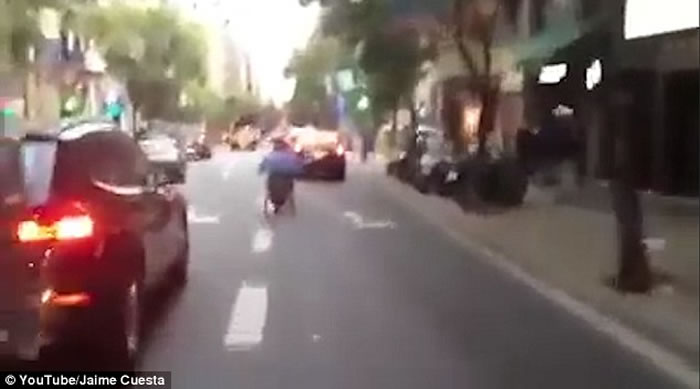 西班牙马路上演惊人一幕:坐轮椅男子在路上飞驰险象横生