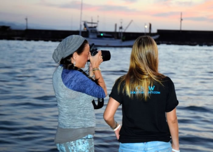 有外国女子用相机拍摄出海围捕时的情景。