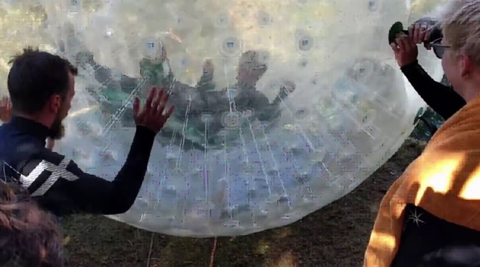 有人坐于巨型太空球中翻滚落湖。