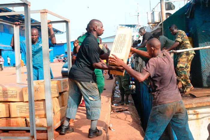 工人由渔船搬下一箱箱的物品。