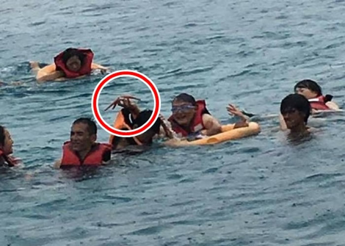 旅客到海中抓海星拍照。