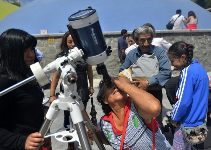 墨西哥籍游客一尝用特别望远镜观看日全食的滋味。