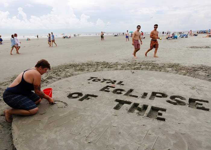 沙滩客用心堆砌字样迎接日食。