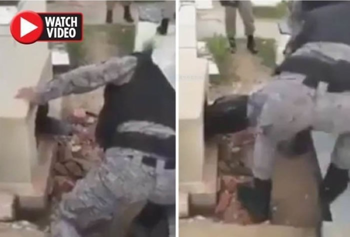 两名警察把被活埋的男子拉出坟墓,然后扶着泣不成声的坐到地上。