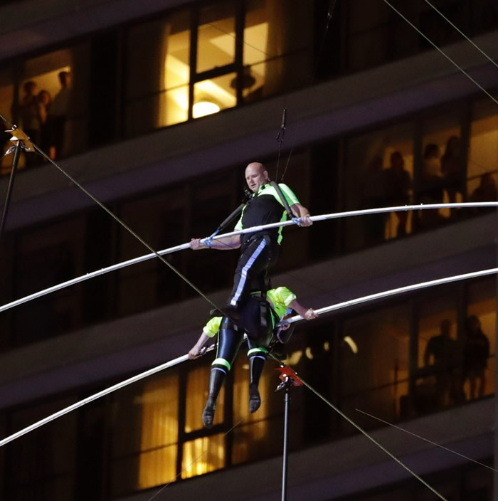 美国著名马戏团“飞翔瓦伦达家族”在纽约时代广场25层楼高度挑战踩钢线