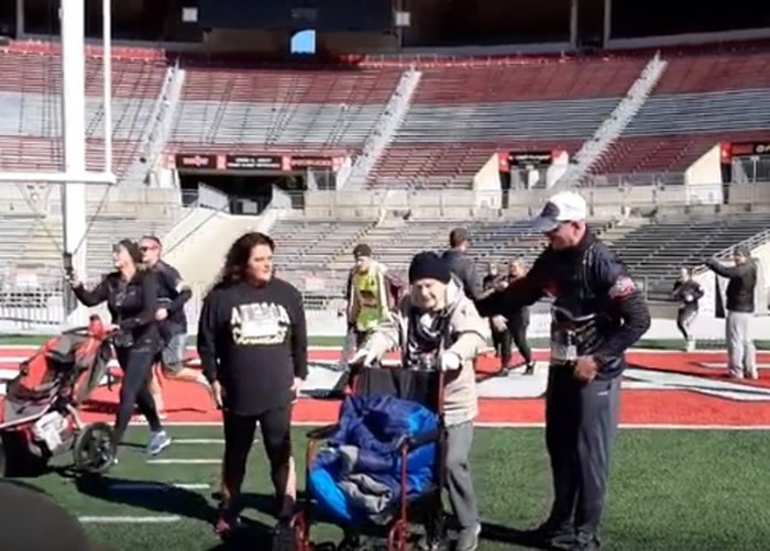 施特勒贝尔(中)紧抓轮椅向前走。