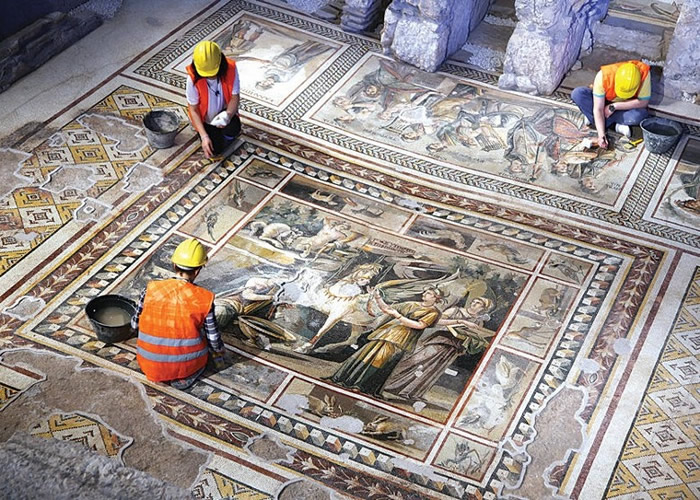 施工期间，考古人员及工人小心整理文物。