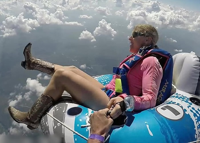 美国佛罗里达州女跳伞好手坐在充气水泡上与同伴从4000米高空的飞机一跃而下