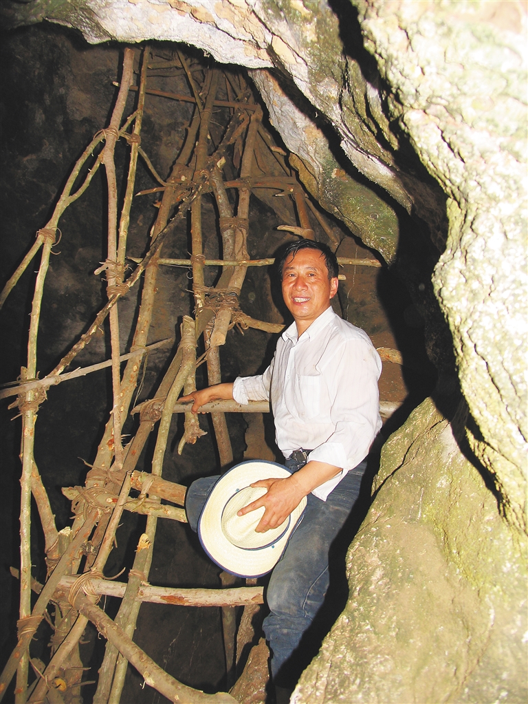 李超荣在使用黎族村民用藤条搭建而成的考古脚架