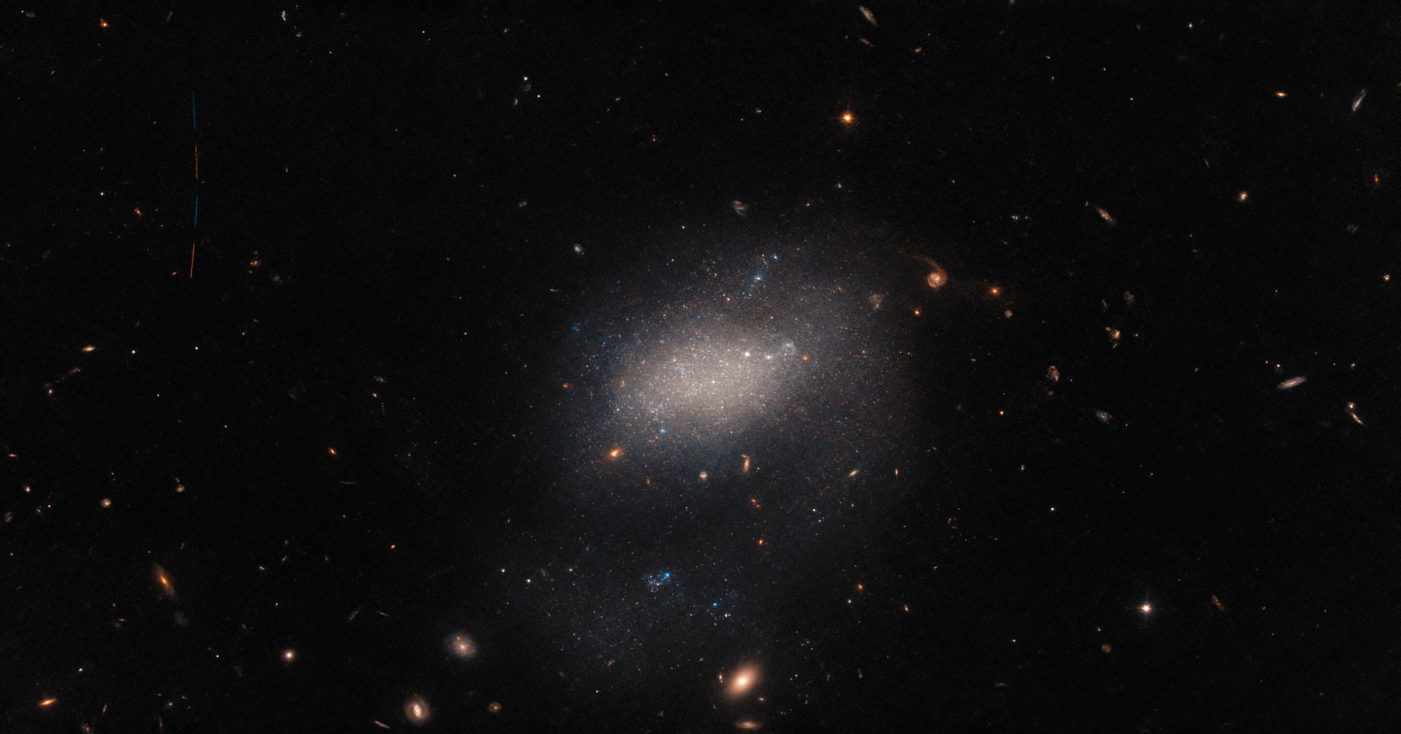 哈勃太空望远镜拍摄小星系UGC 7983 照片隐藏一颗小行星掠过的痕迹